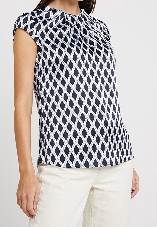 Blusa navy con un patrón de diamantes blancos, mangas cortas tipo cap, escote fruncido y una tela suave y ligera.
