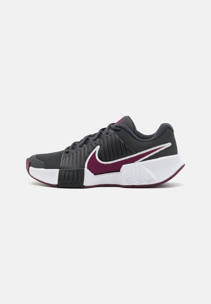 Nike sportsko med en grå mesh-overdel, hvid sål, maroon accenter, teksturerede sider og en forlænget form. Har et fremtrædende swoosh-logo.