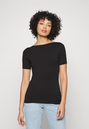 Svart kortermet topp med båthals, laget av elastisk stoff, tettsittende design, kombinert med lyseblå jeans. Jevn tekstur, minimal detaljering.
