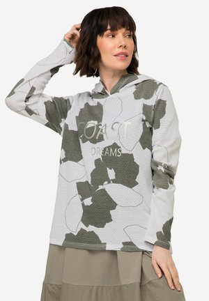 Felpa con cappuccio in maglia a rete con base bianca e grandi motivi floreali verdi. Presenta la scritta "COAST DREAMS" in un font leggero.