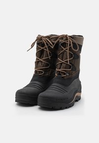 Bottes d'hiver imperméables marron et noires avec une semelle en caoutchouc texturée, un tige rembourrée et un système de laçage avec des lacets et des accents marron.