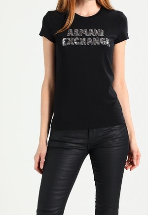 Czarny t-shirt z krótkim rękawem i okrągłym dekoltem, z napisem "ARMANI EXCHANGE" wykonanym srebrnymi metalicznymi literami na przodzie.