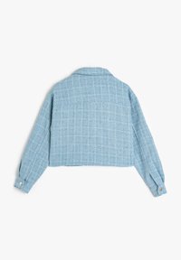 Giacca blu in tweed tagliata con un colletto strutturato, maniche lunghe, polsini con bottoni e un motivo a quadri testurizzato sul tessuto.