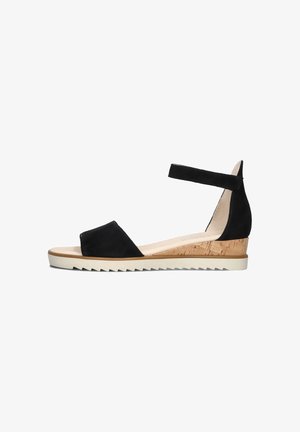 Black suede wedge sandal with ankle strap, cork base, and rubber sole. Features a smooth upper and open toe design. Textured outsole for grip.