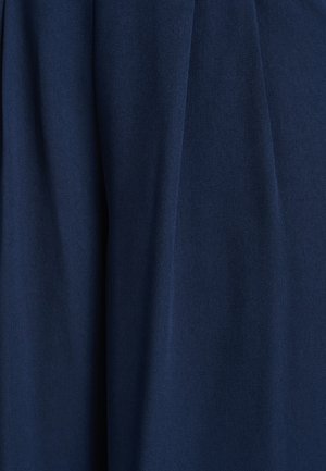 Tamnoplava tkanina s glatkom teksturom i mekim padajem; karakteriziraju je istaknuti nabori, što ukazuje na naborani dizajn.