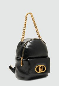Zaino in pelle nera dalla forma arrotondata, con una tracolla in catena dorata e una tasca anteriore con zip caratterizzata da un grande logo dorato.