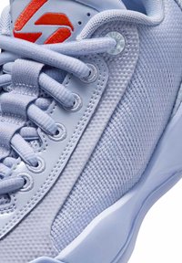 Helle lavendel Sneaker mit strukturiertem Mesh-Obermaterial, Gummisohle und tonalen Schnürsenkeln. Verfügt über einen roten Logoakzent an der Seite für einen markanten Look.