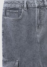 Pantaloni in denim grigio con finitura testurizzata, dotati di tasca anteriore, chiusura a bottone e dettagli con tasche cargo laterali.