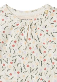 Tissu blanc avec un motif floral composé de fleurs rouges, violettes et orange, accompagnées de feuilles vertes ; comporte un petit bouton doré à l'épaule.
