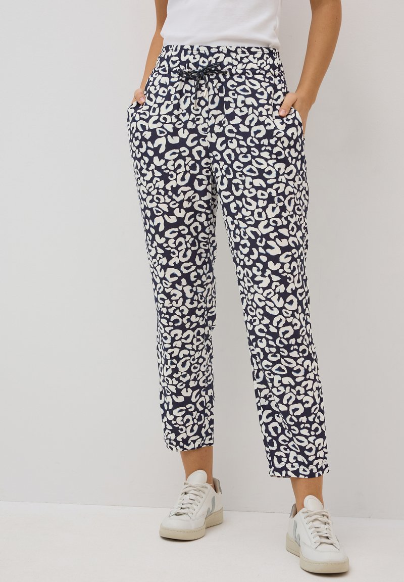 Pantaloni tapered blu navy con stampa leopardata bianca, vita elastica, tasche laterali e cordoncino per una vestibilità regolabile.
