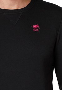 Czarny długi rękaw pulower wykonany z żebrowanej tkaniny; z małym różowym haftowanym logo konia oraz napisem "POLO SYLT" na piersi.
