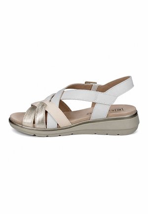 Sandalia tipo slingback con tiras beige, blancas y metálicas, plantilla acolchada y suela de goma beige con ligero tacón cuña.