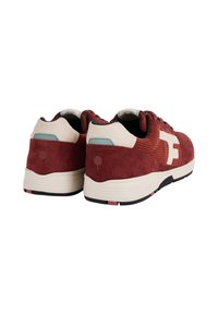 Sneakers in suede rosso con dettagli crema, pannelli testurizzati e suola in gomma con dettagli rossi e neri. Logo sul lato.