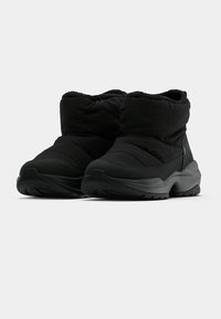 Fekete szigetelt bokacsizmák steppelt felsőrészszel, kerek orral és texturált gumitalppal. Varrott díszítésekkel és húzófegyveres kialakítással rendelkezik.