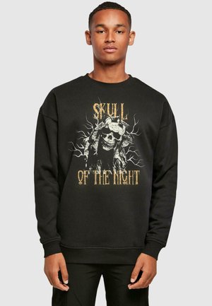 Sort sweatshirt med et grafisk design af et kranium og grene, med guld- og hvid tekst "SKULL OF THE NIGHT" i et fedt design.