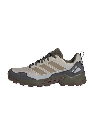 Beiger und olivgrüner Adidas Terrex Wanderschuh mit robuster Sohle, dunklen Schnürsenkeln und Zuglasche an der Ferse, konzipiert für Outdoor-Aktivitäten.