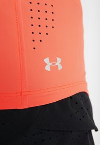 Camiseta sin mangas de Under Armour en color coral brillante con detalles perforados en negro, con un logotipo gris en el lado inferior y una tela suave y elástica.