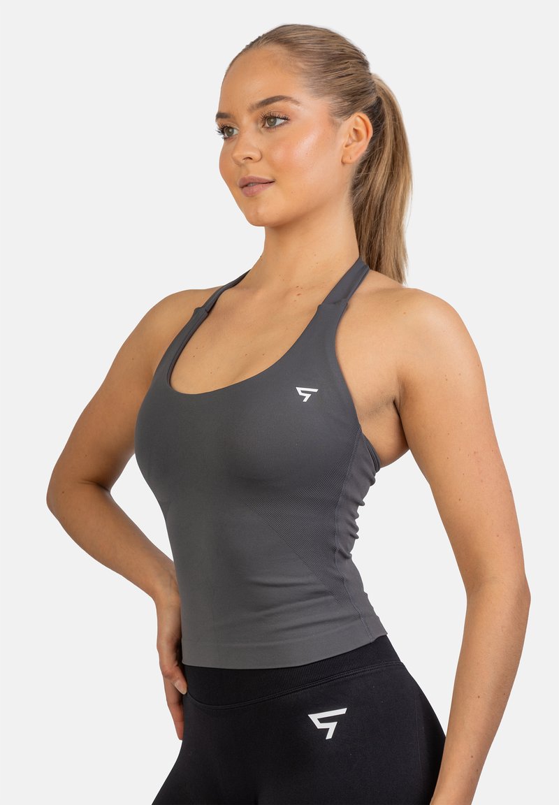 Grijze sporttanktop met een racerback ontwerp, gemaakt van rekbaar materiaal. Heeft een klein wit logo aan de linkerkant en een aansluitende snit.