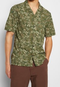 Kortärmad skjorta i grön tyg med ett blommönster inklusive blad och bär, med knapplist framtill och avslappnad passform.