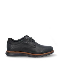 Zapatos de cuero negro con un acabado texturizado, punta redonda y suela de color marrón. Presentan un cierre con cordones y un sutil logo grabado en el costado.
