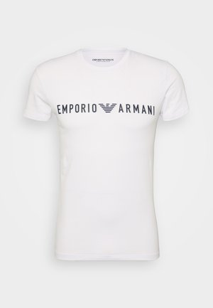 T-shirt en coton blanc à manches courtes, présentant un grand logo "Emporio Armani" bleu marine sur la poitrine et un col ras du cou.