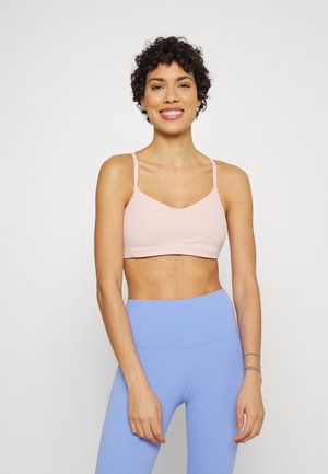 Top desportivo cor-de-rosa claro com alças finas, apresentando um decote em forma de scoop. Combinado com leggings de cintura alta azul claro. Textura de tecido suave.