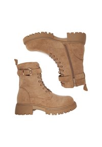 Světle hnědé semišové kotníkové boty s robustní podrážkou, šněrováním v přední části, bočním zipem a detailem s přezkou na kotníku. Texturovaný povrch a odolný design.
