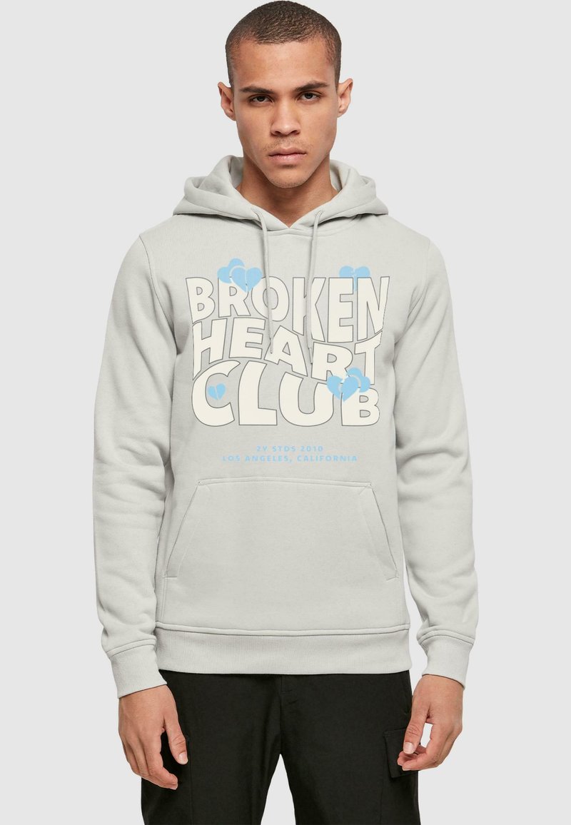 Világosszürke kapucnis felső kenguru zsebbel, élénk kék "BROKEN HEART CLUB" felirattal és felhő mintákkal, puha fleece anyagból készült.