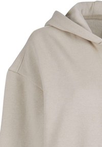 Lys beige hettegenser med myk stoff, kengurulomme og hette med snor. Har avslappet passform og minimale sømdetaljer.