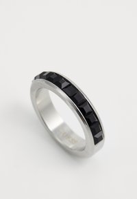 Silver metal ring with a row of rectangular black gemstones set along the outer band on a white background.