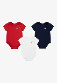 Set de trei body-uri cu mâneci scurte în roșu, alb și bleumarin, realizate din bumbac moale, cu un mic logo negru Nike pe piept.