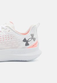 Chaussure de sport blanche avec un dessus en maille texturée, accents roses, logo gris et une semelle blanche rembourrée portant l'inscription "FLOW" avec un design épuré.