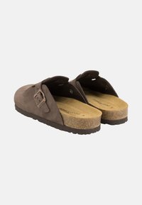 Braune Wildleder-Slipper mit Korkfußbett, verstellbarem Metallverschluss und strukturiertem Gummisohle. Offenes Rückendesign für einfaches Anziehen.
