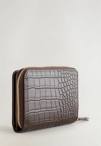 Bruine portemonnee met krokodillenpatroon, een gestructureerd oppervlak, gouden ritssluiting en een compact ontwerp, met een afgeronde vorm en naadloze randen.