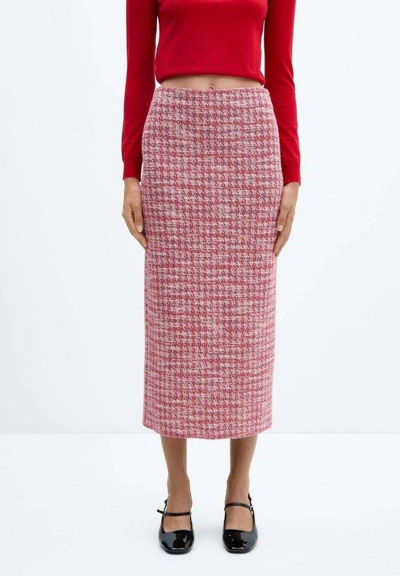 Haut rouge  à manches longues associé à une jupe crayon longueur genou avec un motif pied-de-poule dans des nuances de rose et blanc. Chaussures plates noires.