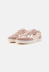 Ružové semišové tenisky s trblietavým zvrškom, bielymi bočnými prvkami a priehľadnou gumovou podrážkou. Dizajn dopĺňajú šnúrky a polstrovaný golier.