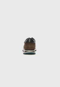 Braune Wildleder- und schwarze Leder-Sneaker mit gepolsterter Sohle, kontrastierenden weißen und blauen Details sowie einem glatten Zehenkappen-Design.