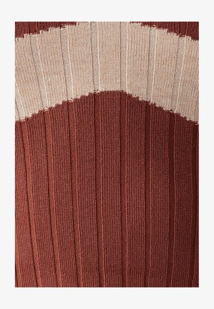 Adītas džemperis ar ribotu tekstūru, kas veidota maiņus rūsu un bēša krāsās, ar izliekta dizaina rakstu ap krūtīm.