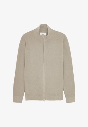 Beige cardigan med lynlås lavet af ribstrikket stof. Har en høj krave, lange ærmer og et lige snit med en glat lynlås.