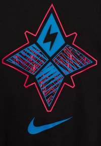 Musta kangas esitleb geomeetrilist mustrit siniste ja roosade aktsentidega. Pikselöök ja jooned loovad dünaamilise mustri sinise Nike logo kohal.