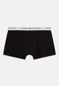Schwarze Boxershorts aus Baumwolle mit einem weißen Bund, der die Marke "TOMMY HILFIGER" trägt. Klassisches Design mit figurbetontem Schnitt.