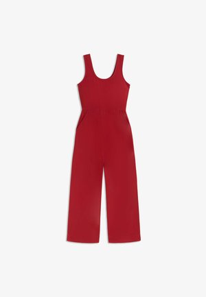 Combinaison rouge sans manches à jambes larges, encolure dégagée, taille cintrée et poches latérales, étalée à plat sur fond blanc.