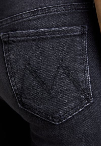 Sorte denimjeans med en særegen baklomme med et broderet "M"-logo. Smooth tekstur og tilpasset pasform med klassisk syning.