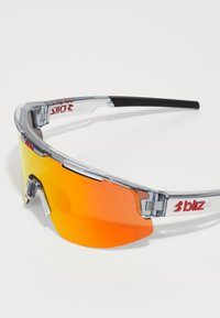 Sport solbriller med en klar ramme og orange gradient linser. Har et strømlinet design og justerbare sorte tempeltips.