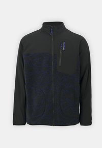 Giacca nera con motivo testurizzato blu sul davanti, taschino a zip sul petto e tasche laterali; progettata con un colletto alto e chiusura frontale a zip.