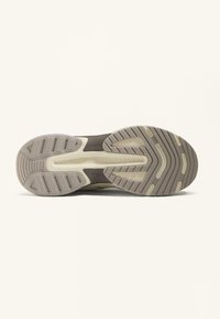 Schuhsohle mit einem strukturierten Gummidesign, das ein beige- und hellgraues Farbschema, Rillen und ausgeprägte Traktionsmuster aufweist.