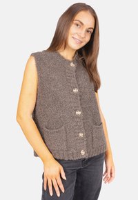 Braun, ärmellose Strickweste aus strukturiertem Stoff, mit vier großen Knöpfen und zwei Fronttaschen. Klassischer Schnitt und neutrale Farbe.