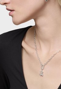 Collana in argento con maglie ovali, decorata con un ciondolo di forme sferiche interconnesse appese a un gancio con chiusura ad anello.
