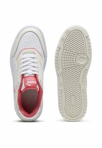Biele kožené tenisky s ružovými akcentmi, textúrovaná gumová podrážka, polstrovaný golier, okrúly priehlavok a perforované detaily. PUMA branding na jazyku.