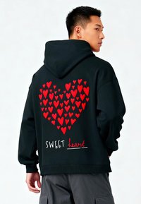 Czarna bluza z kapturem z dużym sercem składającym się z czerwonych serc na plecach, z napisem "SWEET heart" poniżej. Wykonana z bawełny, o luźnym kroju.